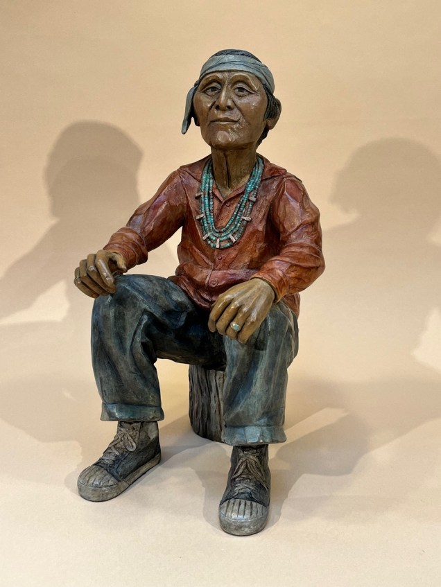 Bronze of a grandfather sitting on a wood stump