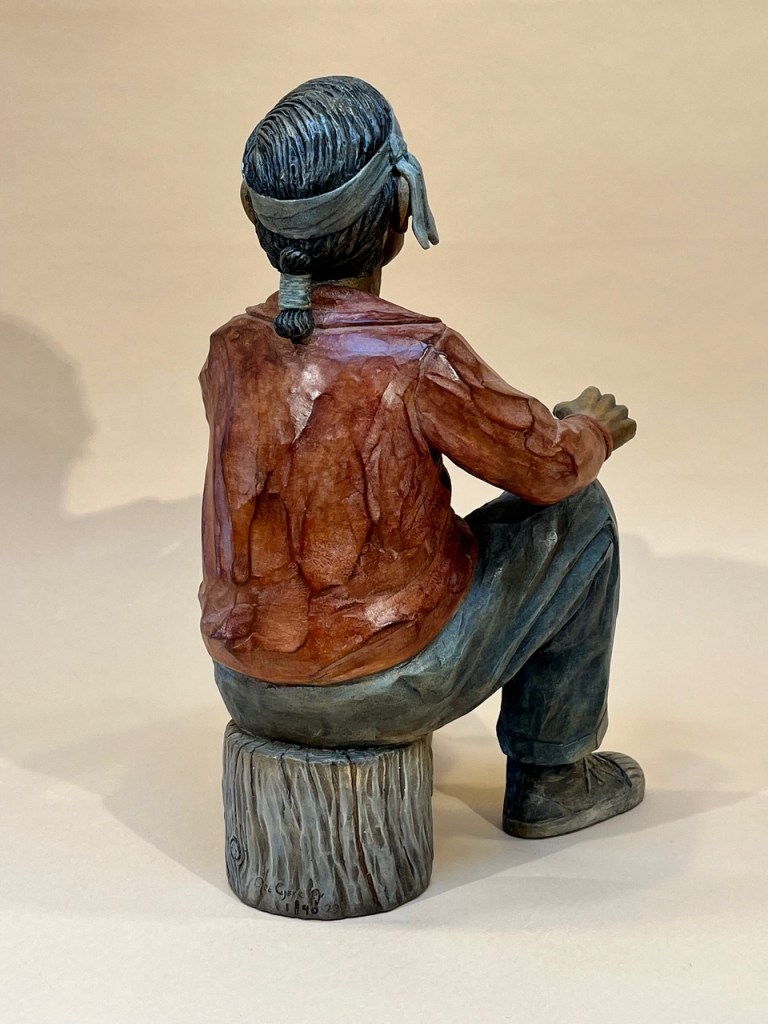Bronze of a grandfather sitting on a wood stump